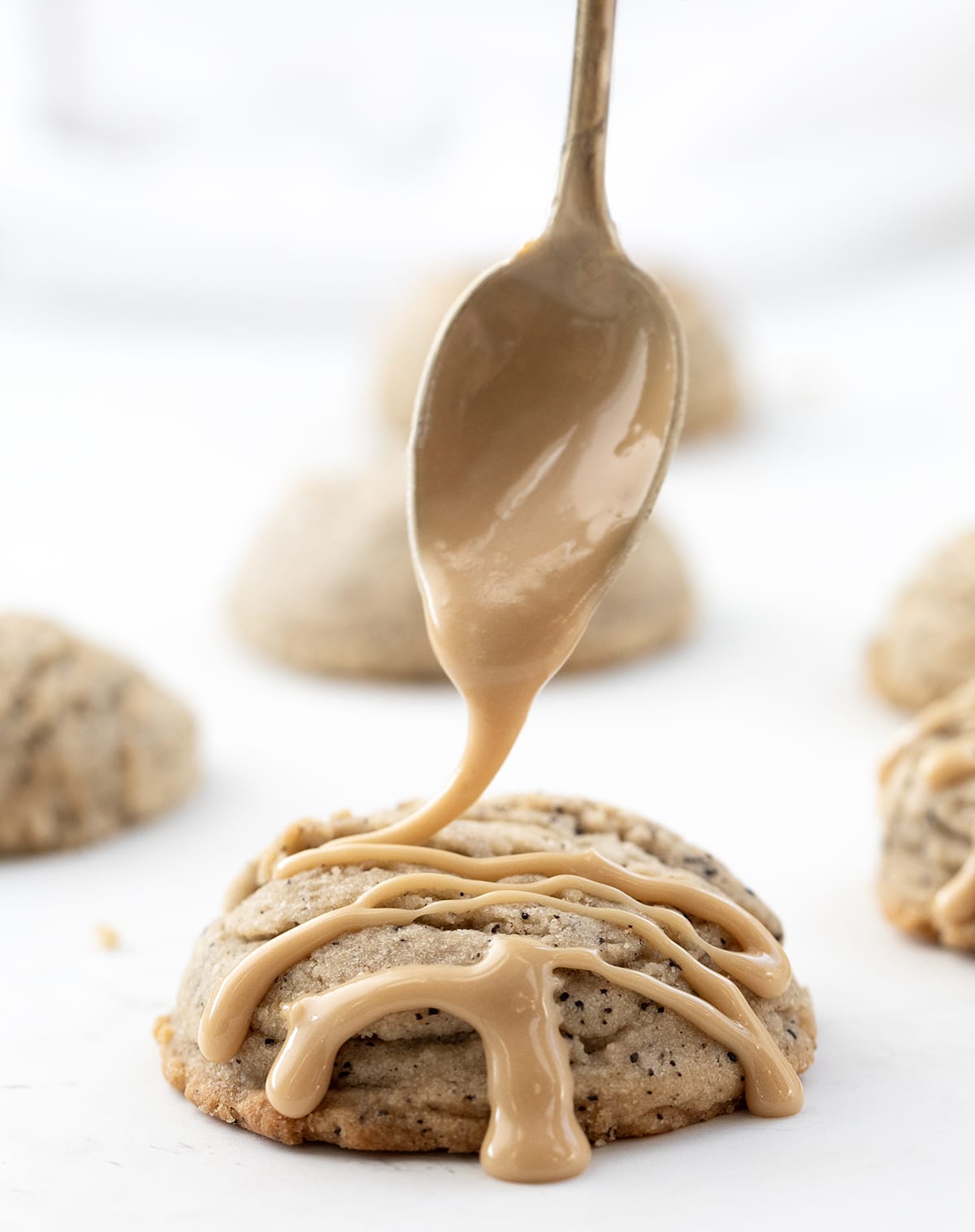 Drizzling Glaze over Coffee Sugar Cookies, The Glaze is Brown as it has been flavored with Coffee.