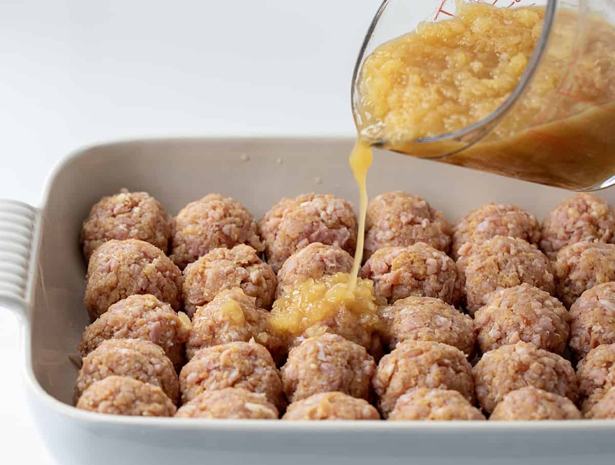 Drizzling Pineapple Sauce Over Pork Meatballs.