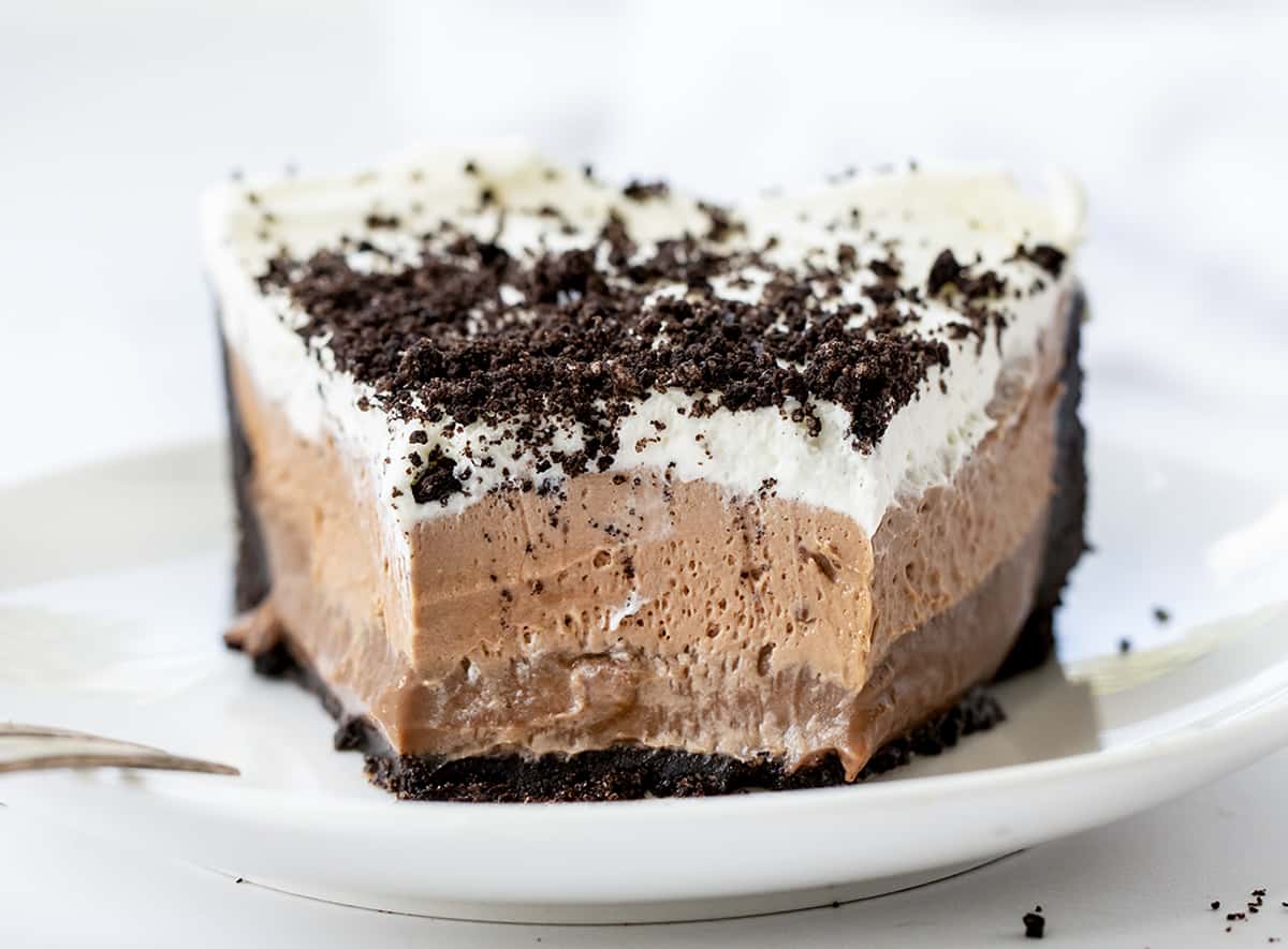 Piece of Triple Chocolate Mousse Pie on a White Plate with Some Removed Showing Texture.