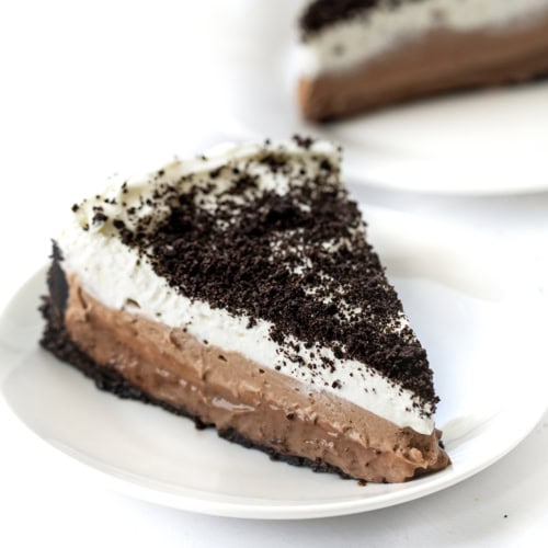 Piece of Triple Chocolate Mousse Pie on a White Plate with Another in the Background.