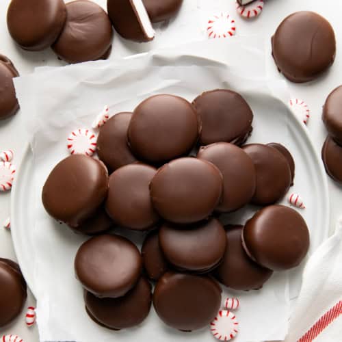 Plate of Homemade Peppermint Patties surrounded by more Homemade Peppermint Patties and a towel from overhead.