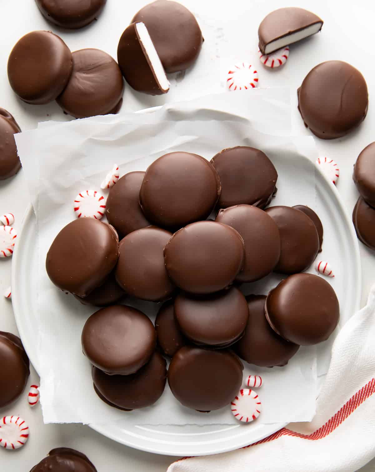 Plate of Homemade Peppermint Patties surrounded by more Homemade Peppermint Patties and a towel from overhead.