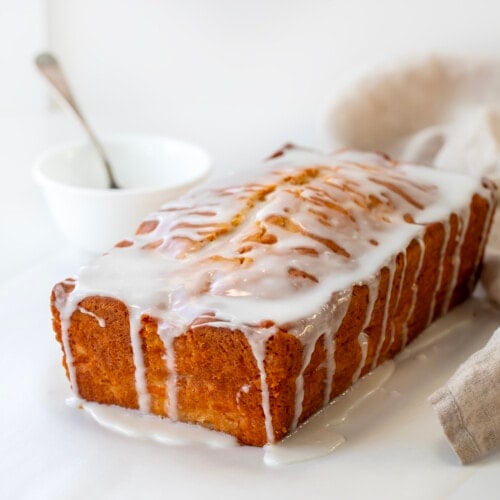 Loaf of Peach Bread on a white counter covered in glaze.