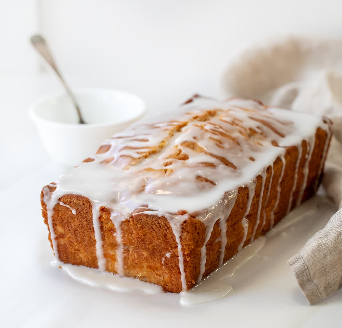 Loaf of Peach Bread on a white counter covered in glaze.