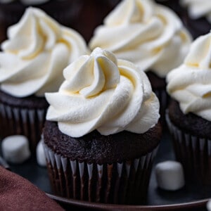 Chocolate Cupcakes with Piped Marshmallow Buttercream on them.