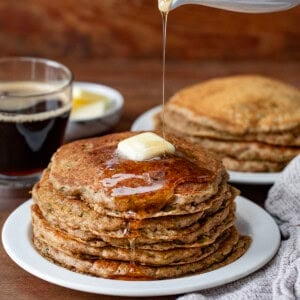 Pouring syrup over a stack of Zucchini Pancakes.