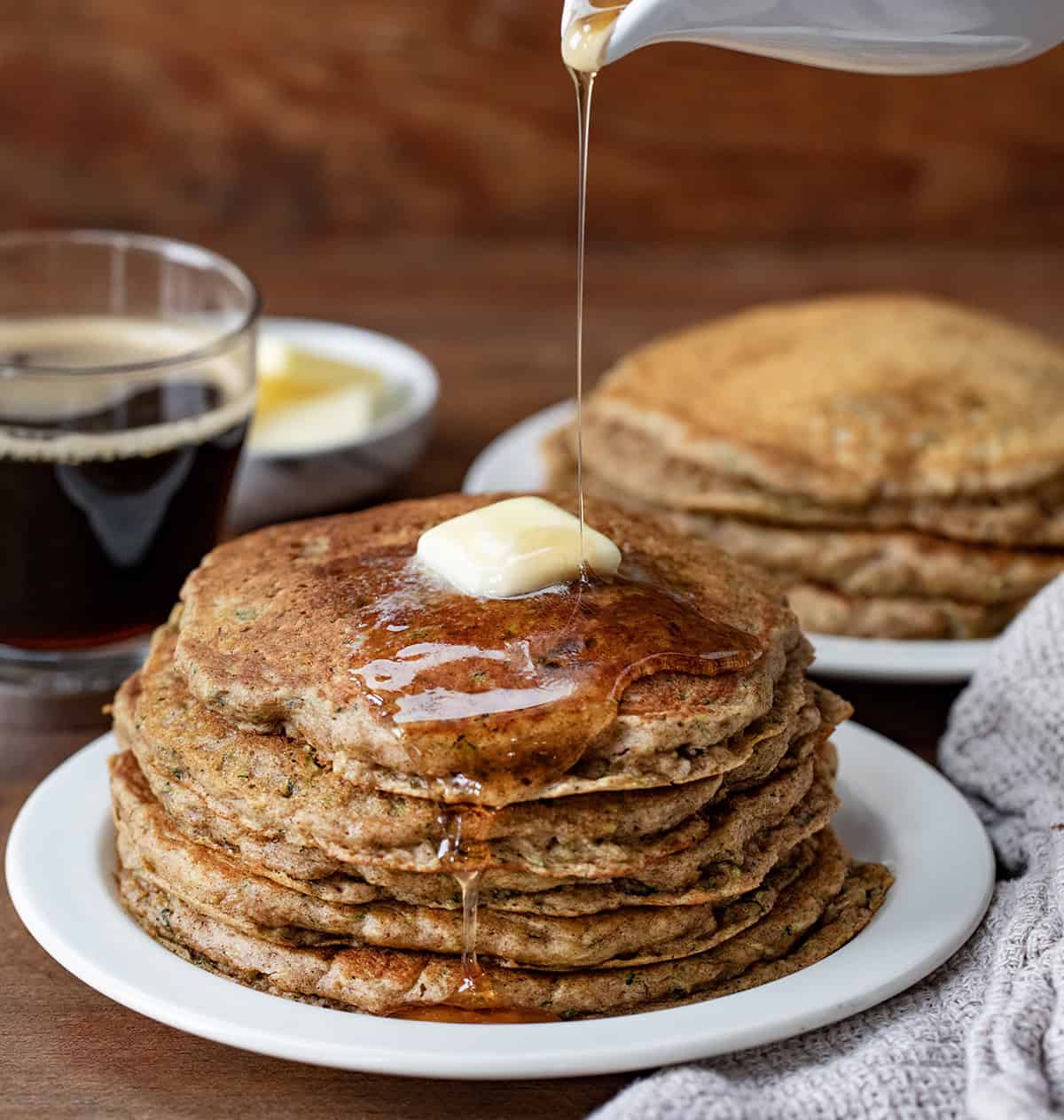 Pouring syrup over a stack of Zucchini Pancakes.