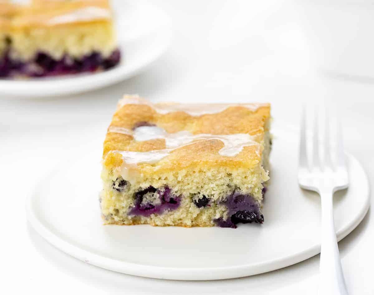 A Couple of Pieces of Blueberry Breakfast Cake on White Plates.