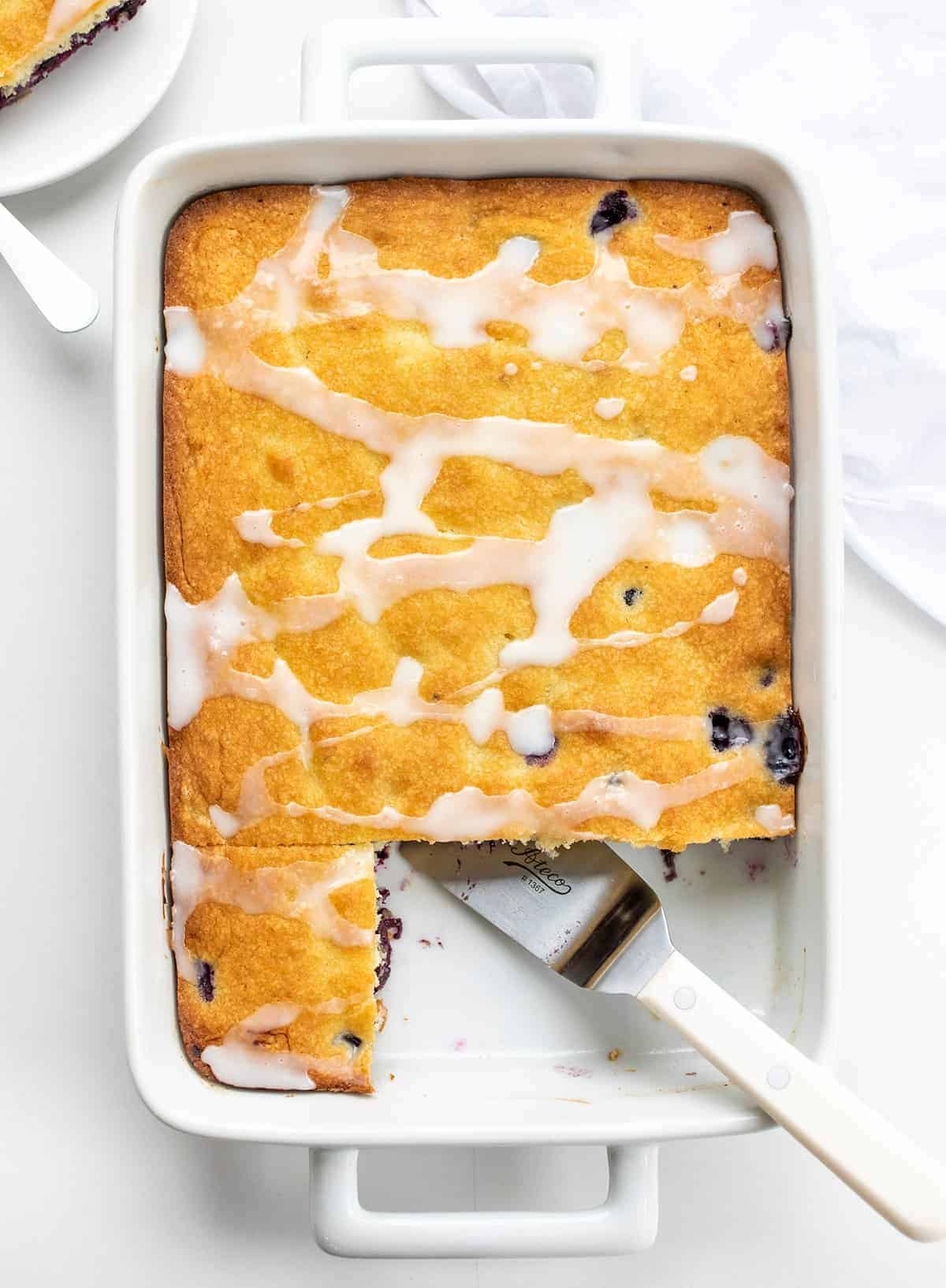 Overhead of Blueberry Cake in Pan With a Couple of Pieces Missing.