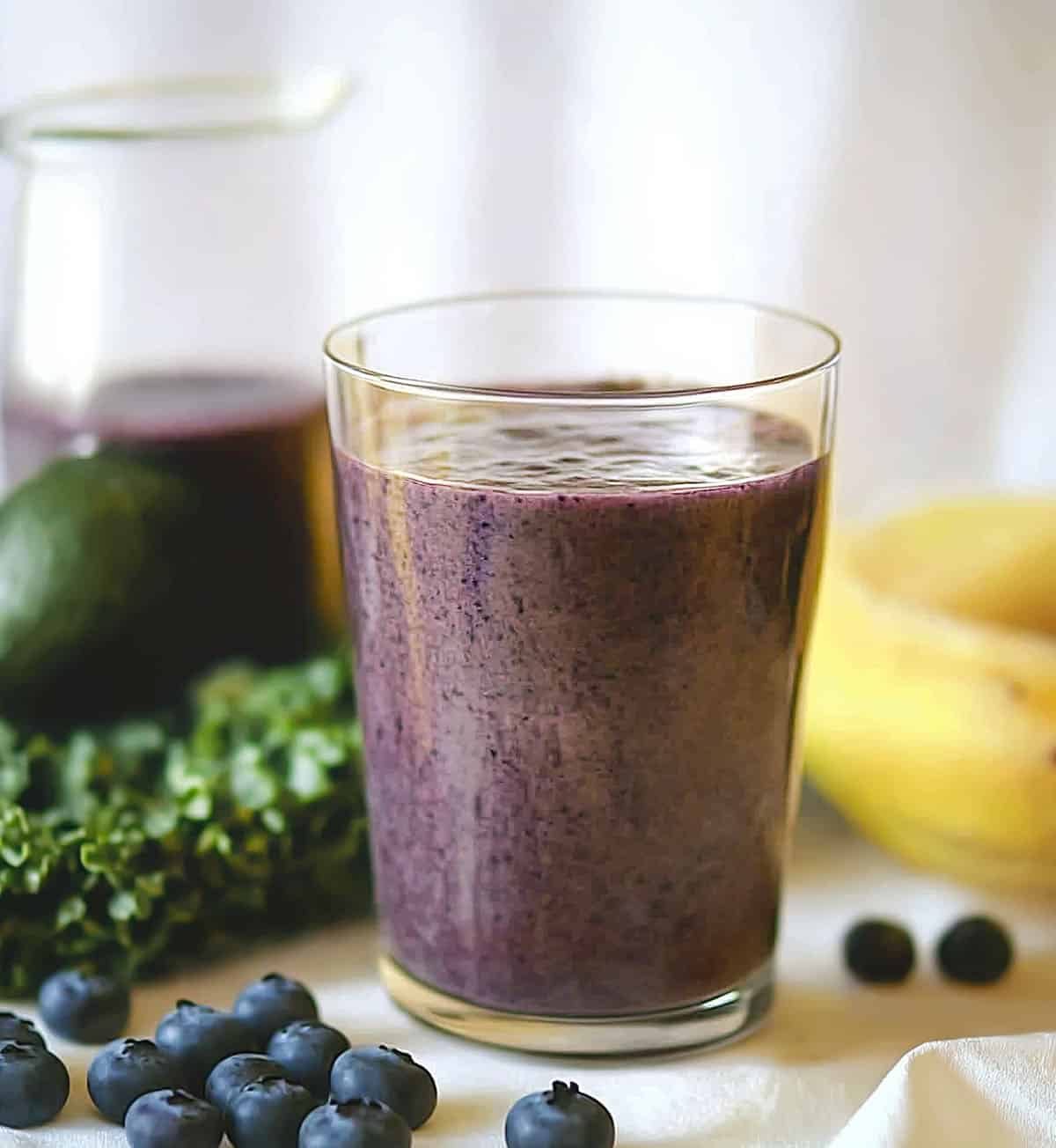 Glass of Blueberry Avocado Smoothie with bananas, blueberries, and avocado. 