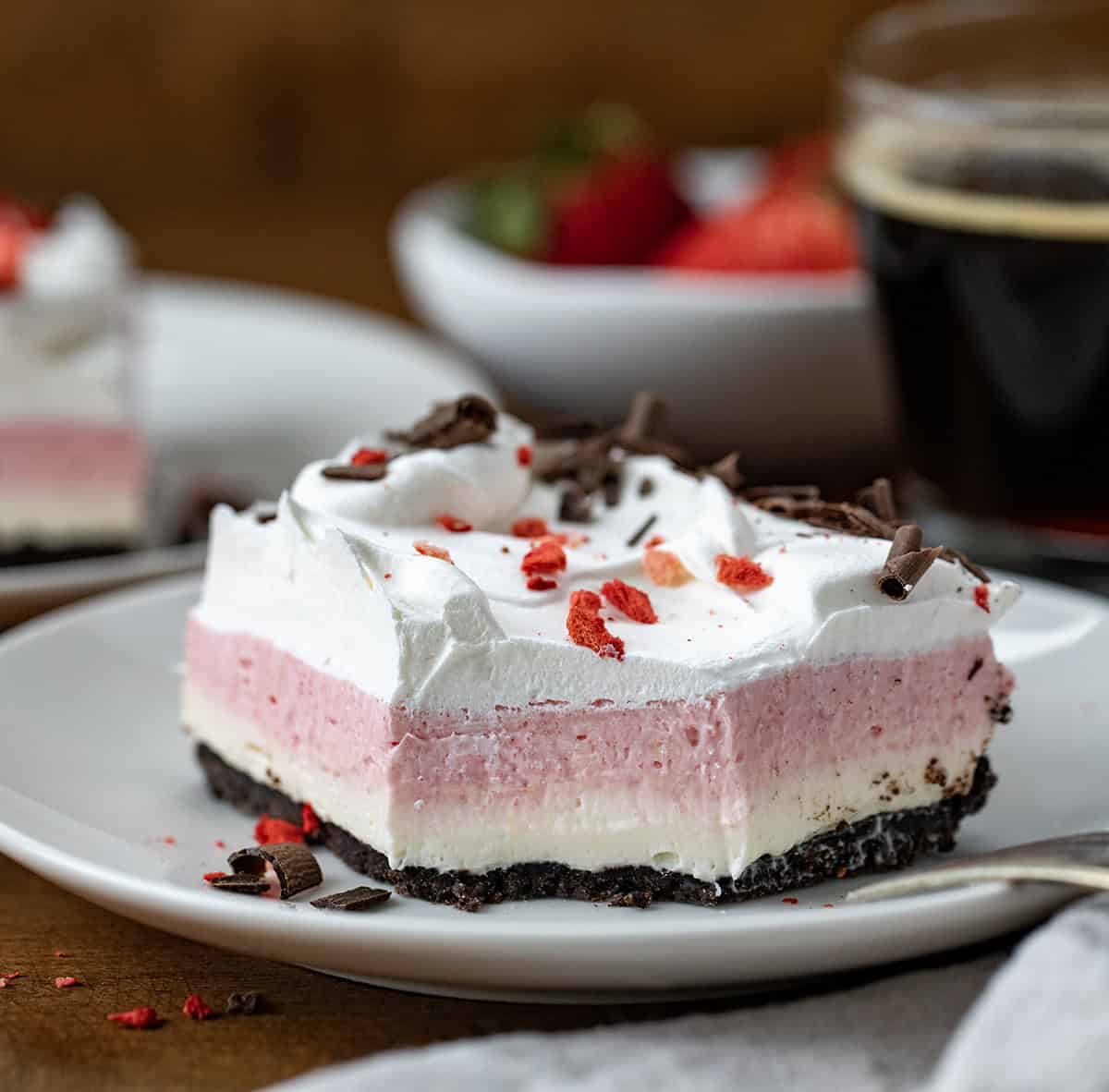 Neapolitan Dessert on a white plate with a bite removed and a fork resting on the plate.