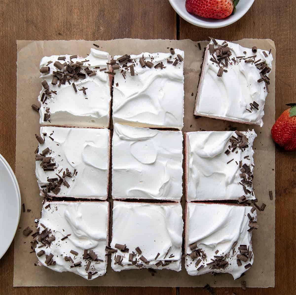 Neapolitan Dessert cut into pieces with fresh strawberries shot from overhead.