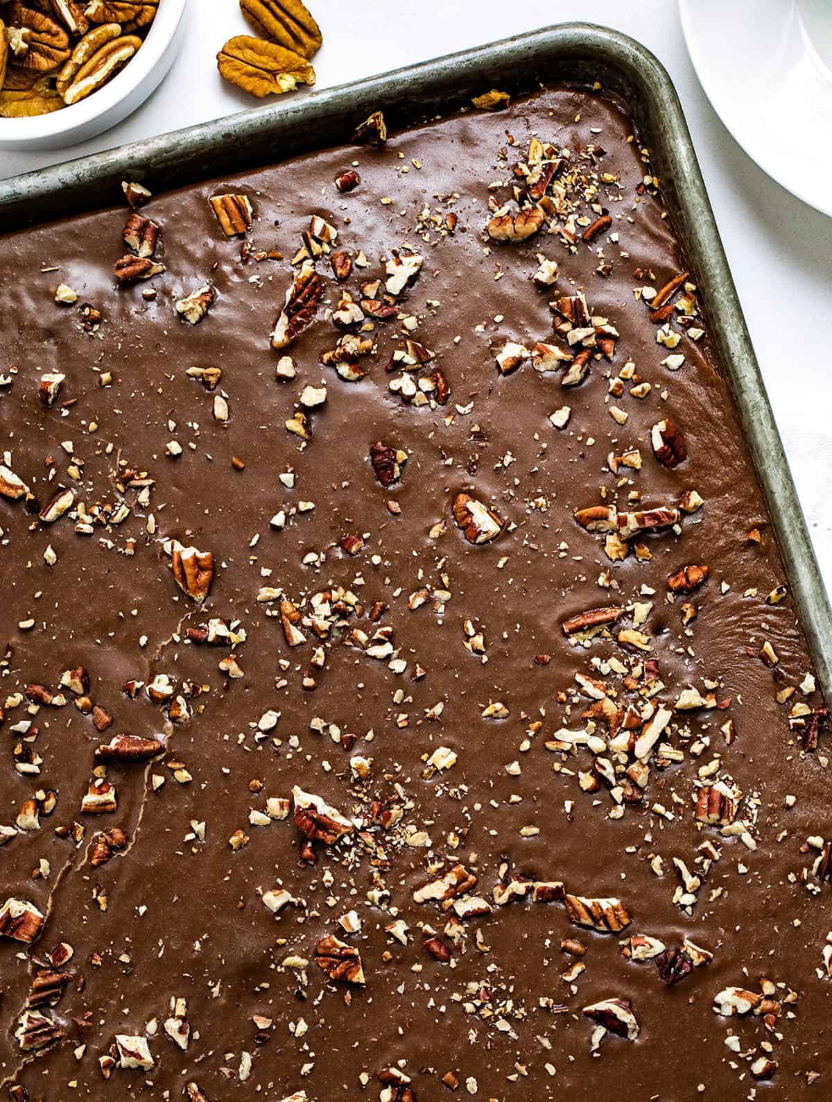 Close up of a pan of Texas Brownie Cake on a white table.