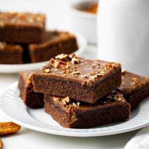 Texas Brownie Cake on white plates with pecans.