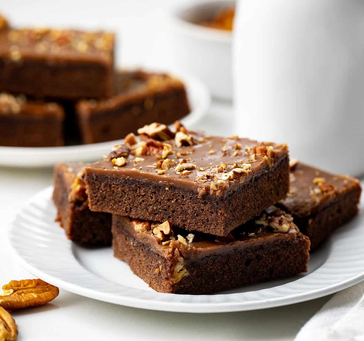 Texas Brownie Cake on white plates with pecans.