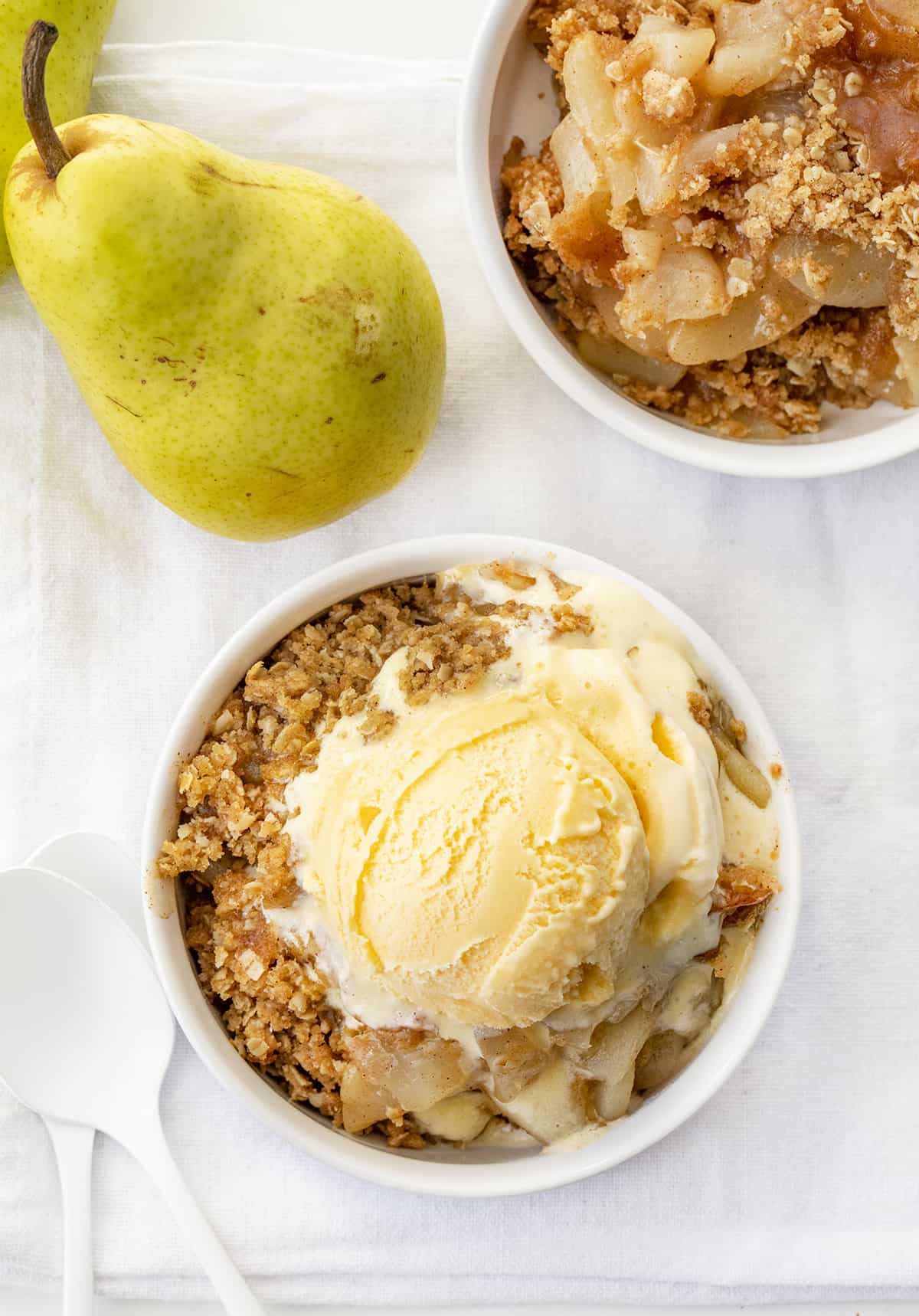 Image of Dishes of Gingered Pear Crisp with Ice Cream and One without Ice Cream. Dessert, Baking, Crisp, Best Crisp Recipes, Pear Crisp, Easy Pear Crisp, Holiday Desserts, Holiday Recipes, Old Fashioned Recipes, Historic Recipes, Grandma's Recipes, i am baker, iambaker