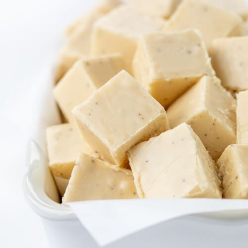 Pieces of Brown Butter Fudge in a White Baking Dish on a White Counter.
