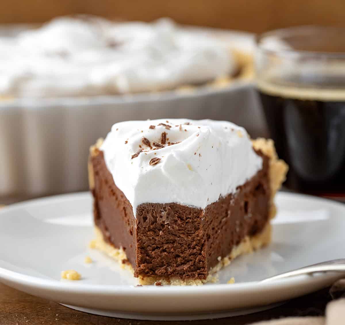 Piece of Rich Chocolate Pie with a bite removed on a white plate.