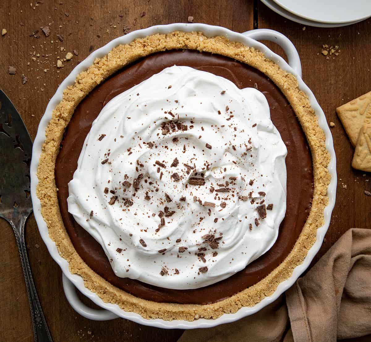 Whole Rich Chocolate Pie  in a white pie pan on a wooden table from overhead.