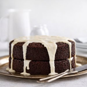 Whole Chocolate Beer Cake covered in beer glaze on a white table.