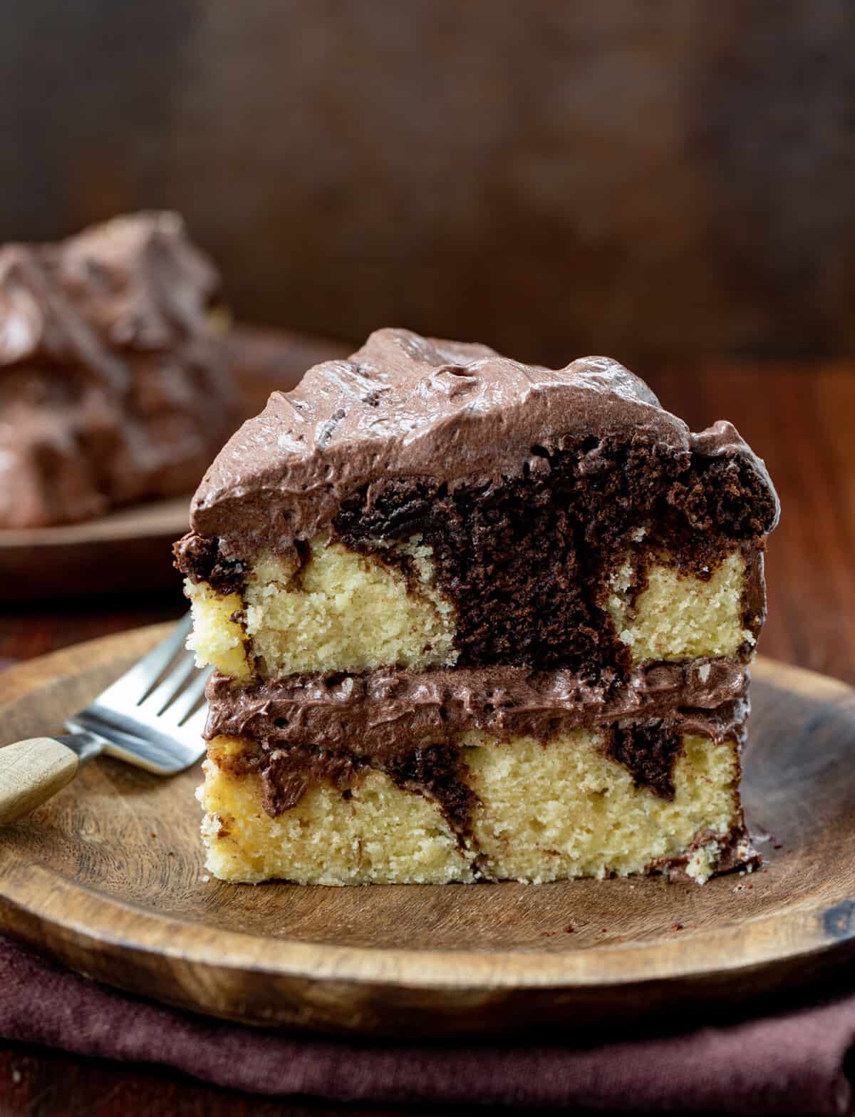Piece of Marble Cake on a Plate with Chocolate Ermine Frosting.