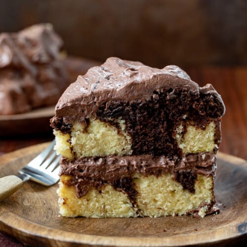 Piece of Marble Cake on a Plate with Chocolate Ermine Frosting.