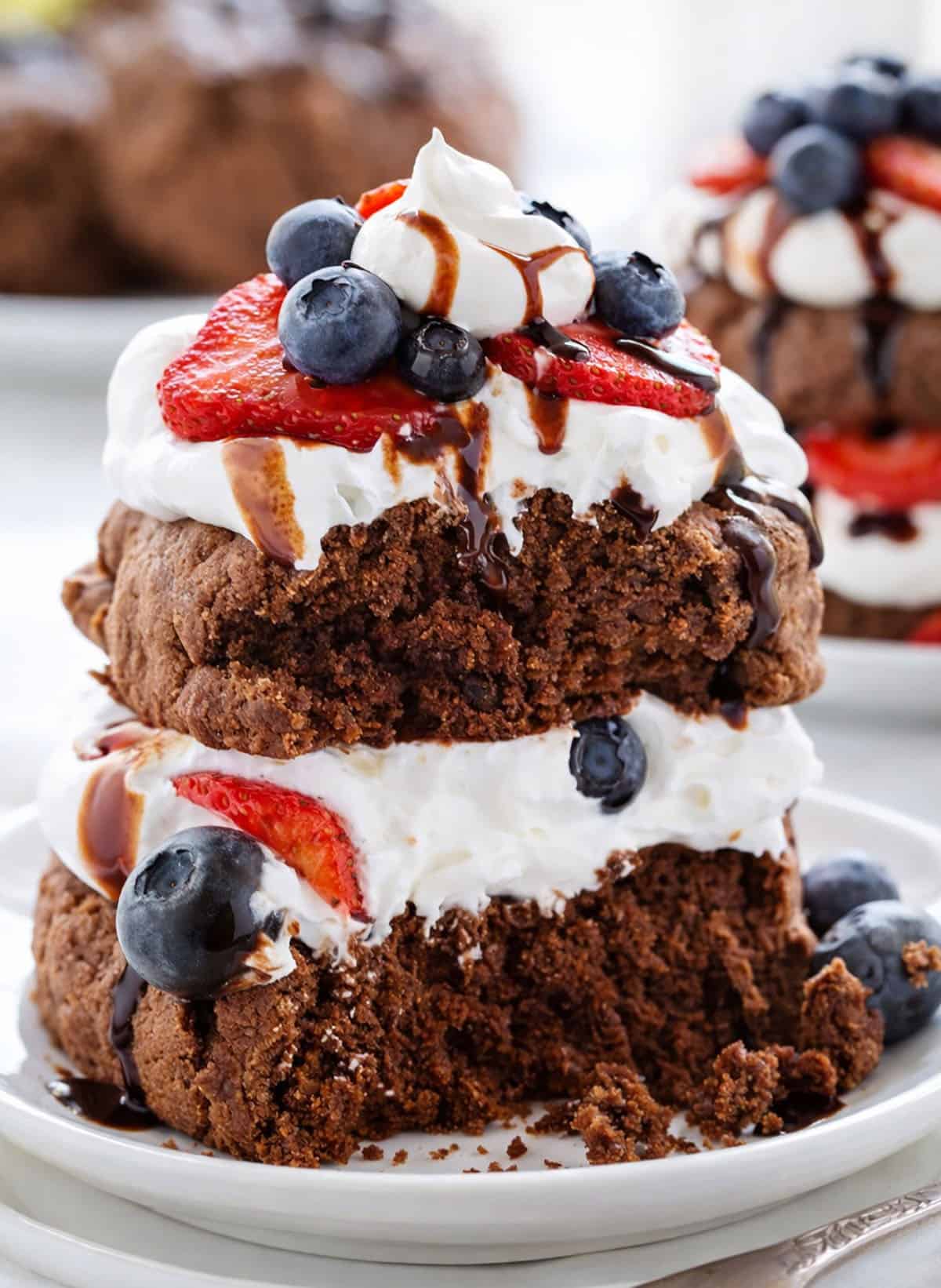 a Chocolate Strawberry Shortcake on a white plate with some of the shortcake eaten.