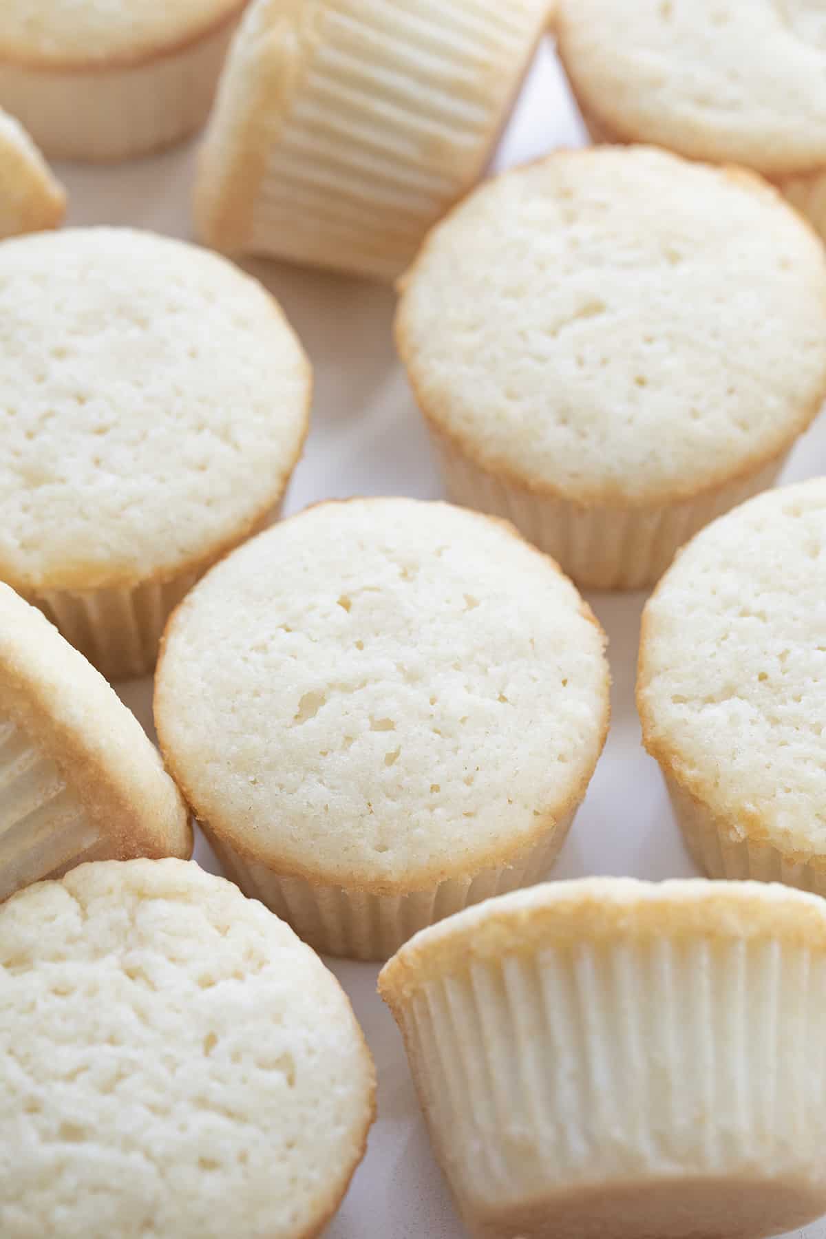 White Cupcakes on a Counter Spread Out and Some on Their Sides.