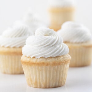 White Cupcakes with Vanilla Frosting on a White Counter.