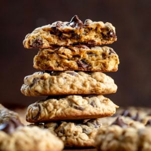 Stack of Oatmeal Chocolate Chip Cookies with the top cookie broken in half showing the inside texture.