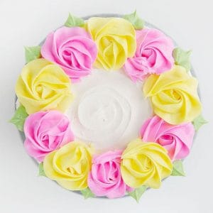 Create simple rustic lines in buttercream and then adorn with pink and yellow buttercream rosettes!