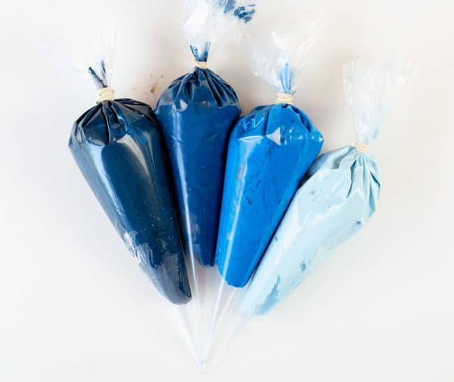 Shades of blue frosting in pastry bags.
