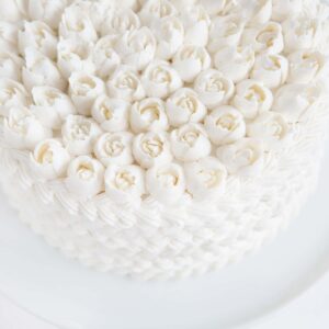 Cake covered in white butercream with Russian tip roses on top!