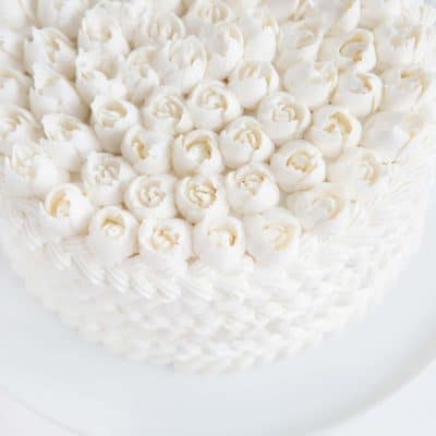 Cake covered in white butercream with Russian tip roses on top!