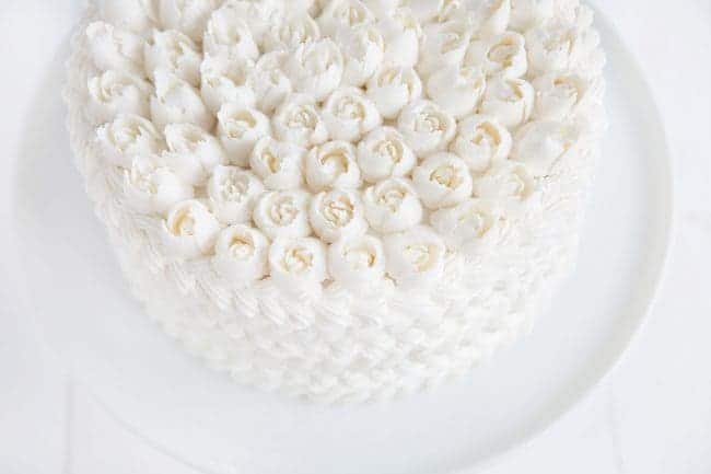 Cake covered in white butercream with Russian tip roses on top!