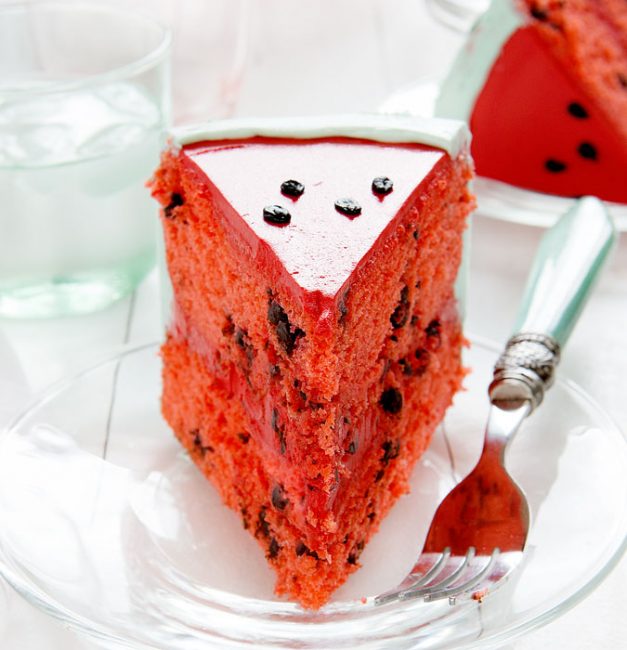 Slice of a cake that is decorated to look like a watermelon inside and out!