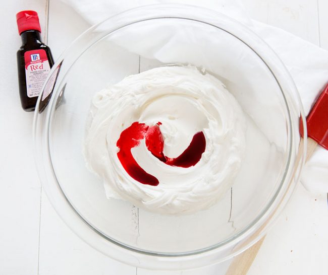 Tinting frosting red for a watermelon cake!