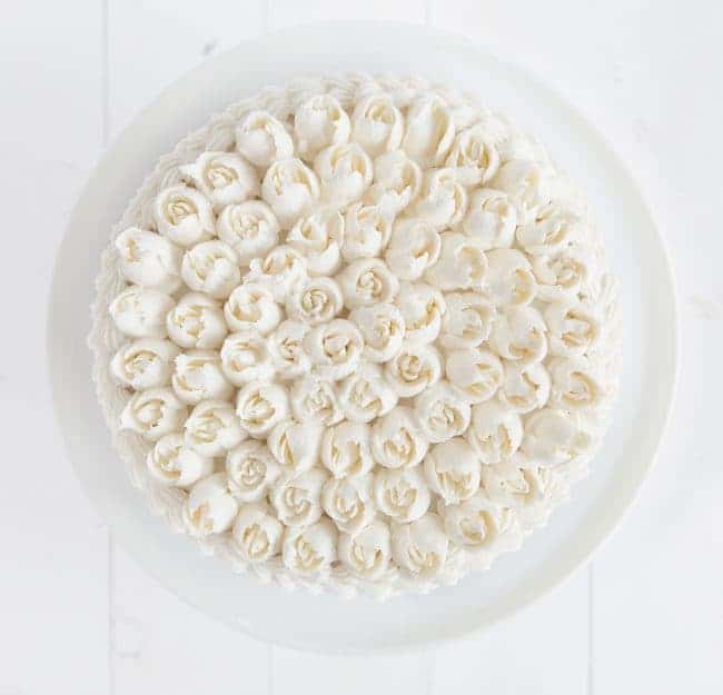 Overhead view of a cake covered in Russian tip roses with whipped vanilla buttercream.