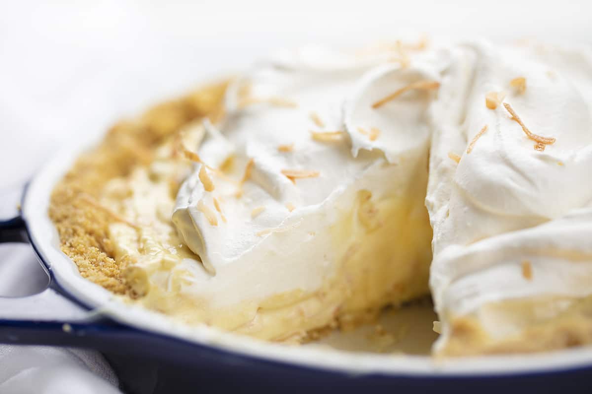 Coconut Cream Pie with One Piece Removed in Blue Pie Pan