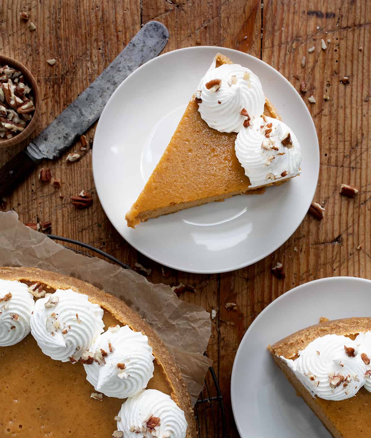 Pumpkin Cheesecake on a Wooden Table with Pieces on Plates from Overhead.