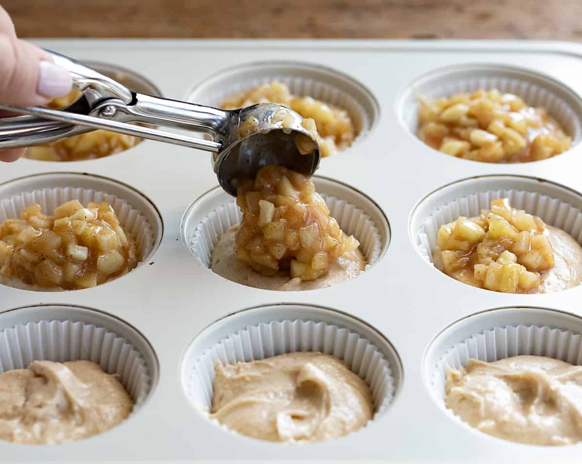Apple Pie Cupcakes are perfectly spiced, tender cupcakes baked with apple pie filling and topped with stabilized whipped cream. So tender and delicious! They are reminiscent of a slice of apple pie but in convenient cupcake form! Adding Apple Pie Filling to Cupcake Batter.