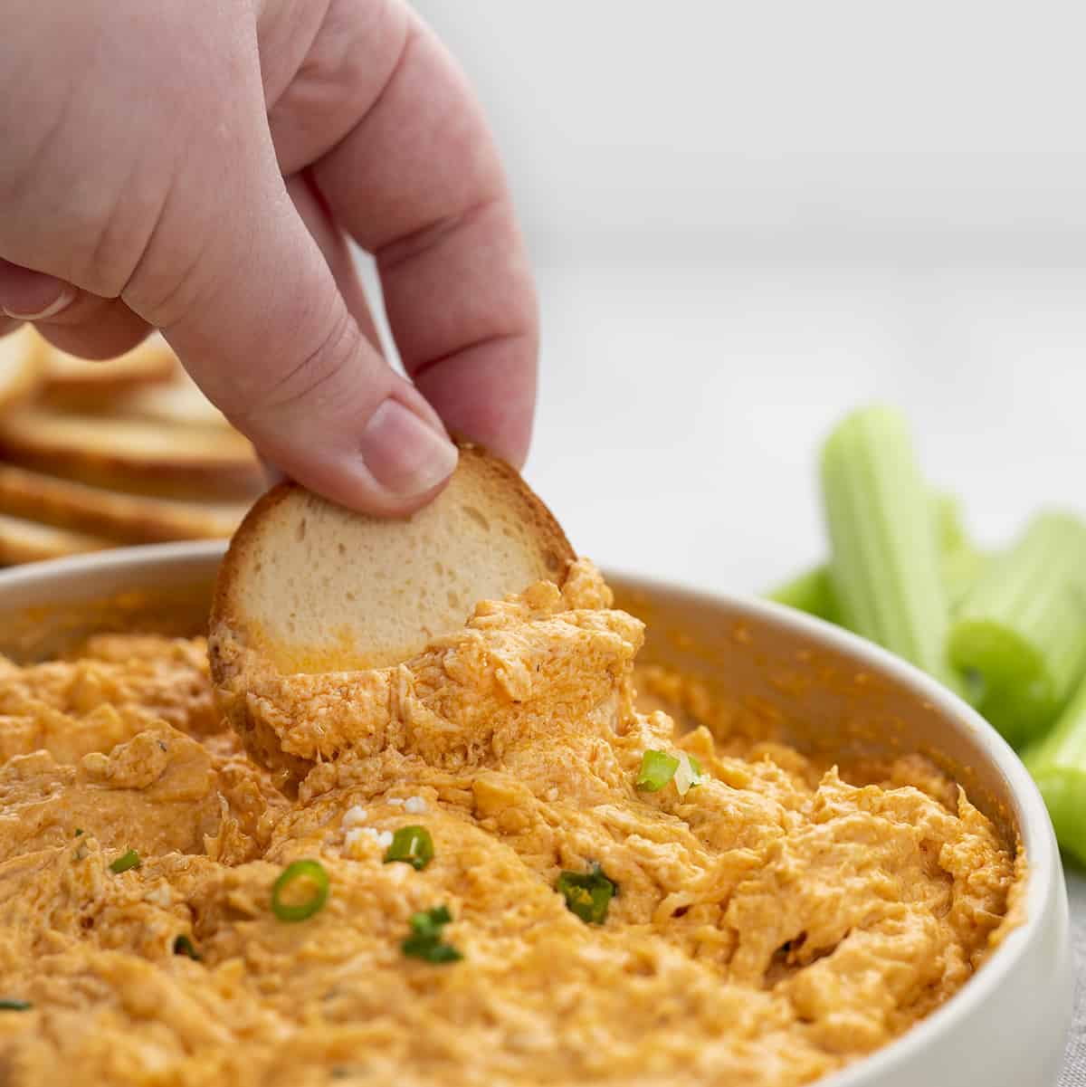 Hand Scooping Buffalo Chicken Dip with Bagel Chip