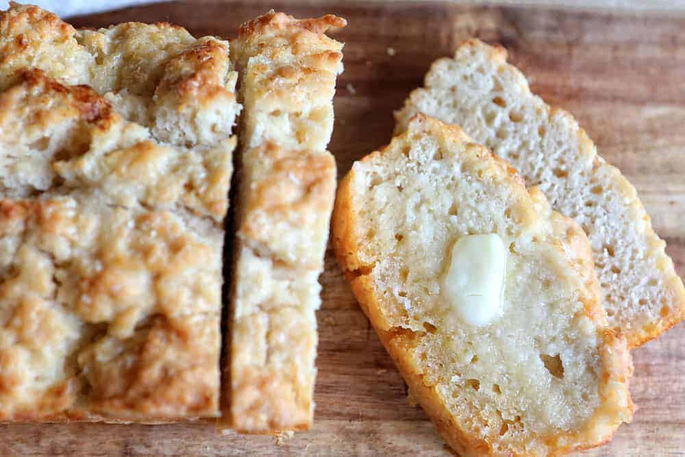 Beer Bread on Cutting Board Showing Slices and Butter Melting on It