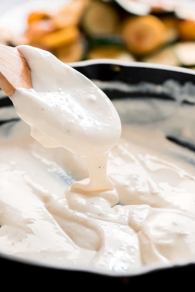 Cheese Sauce on a Spoon for Easy Scalloped Zucchini