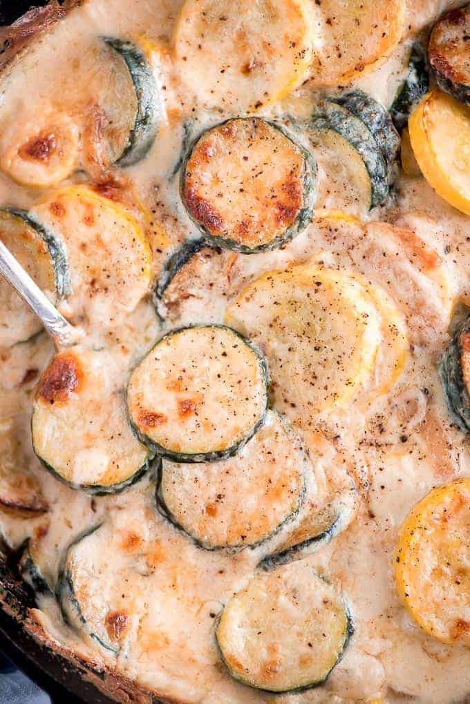 Easy Cheesy Cheesy Scalloped Zucchini from Overhead in a Skillet with Spoon