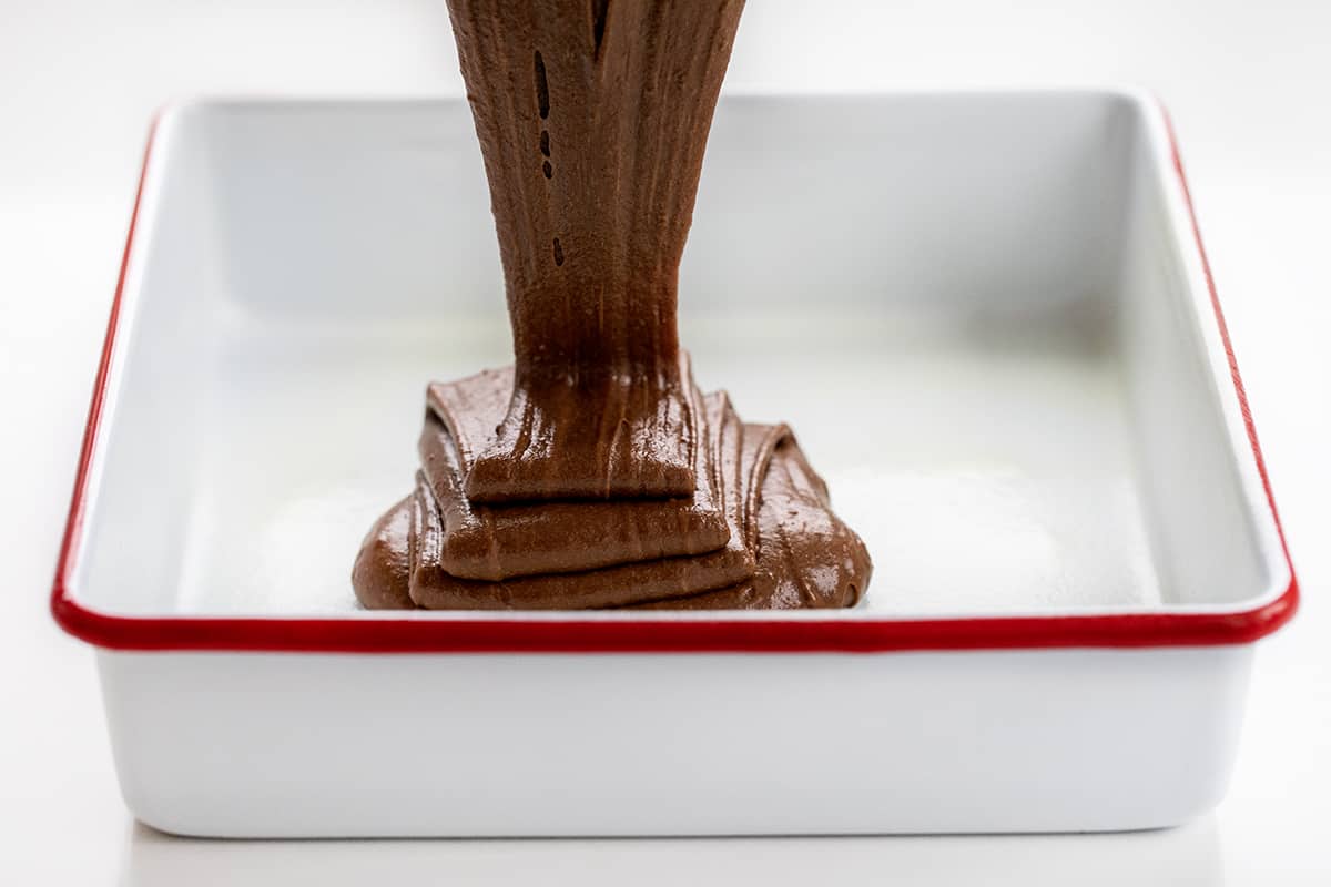 Pouring Chocolate Mayo Cake Batter into a White Pan.