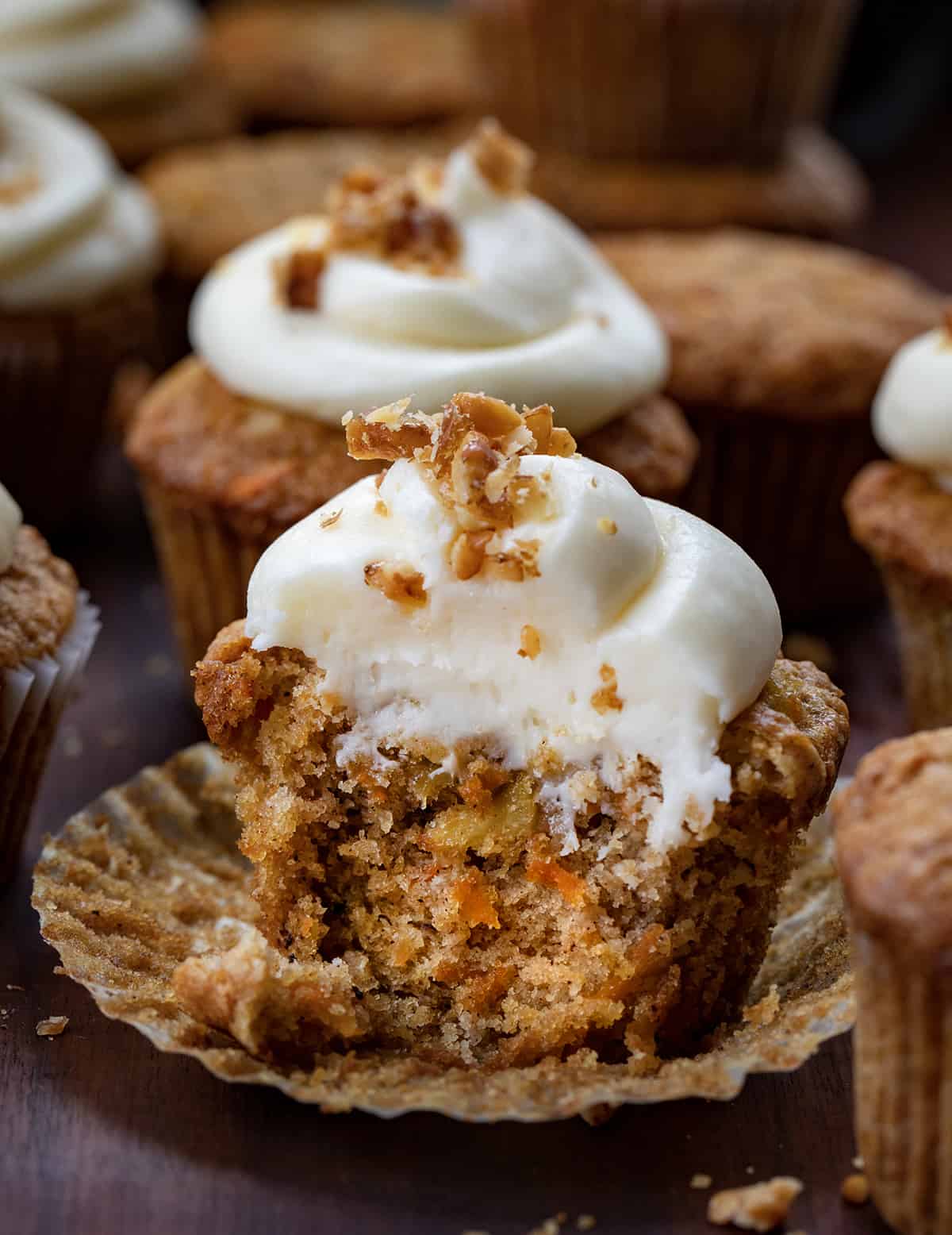 Carrot Cake Cupcake Next to Each Other and One with Some removed Showing the Inside Texture.
