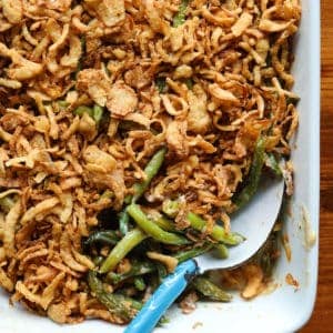 green bean casserole in serving dish with a serving spoon.
