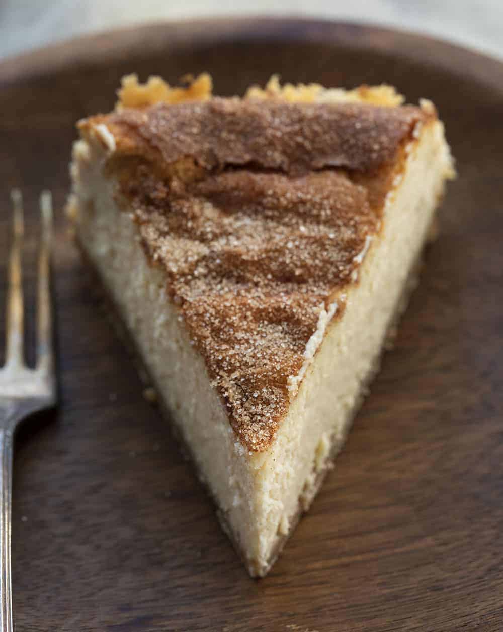 One Slice of Snickerdoodle Cheesecake on Wood Plate