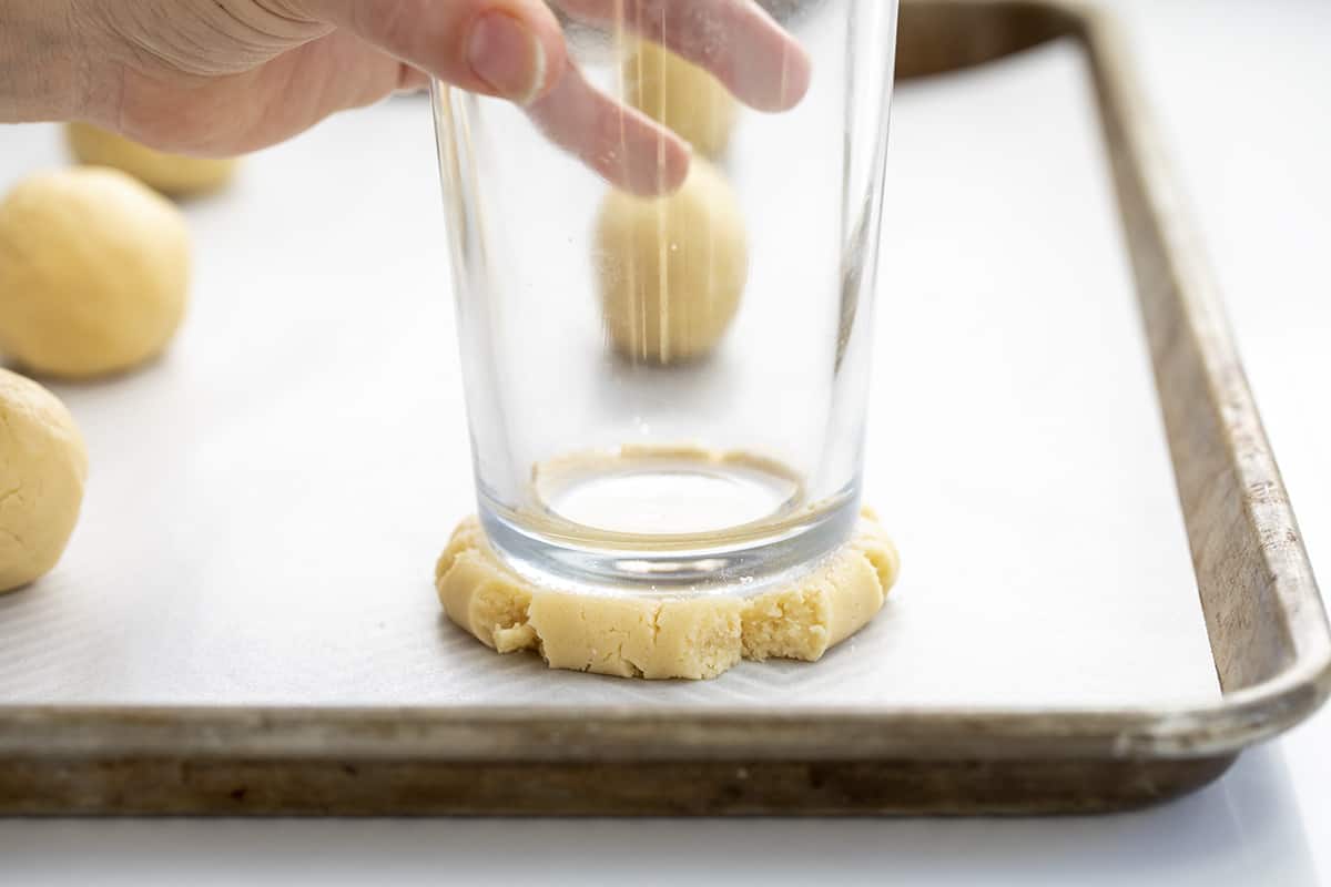 Glass Pressing Down Ball of Sugar Cookie Dough. Dessert, Cookies, Cookie Recipes, Swig Copycat, Baking, Cookie Exchange, Frosted Cookies, iambaker cookie recipes, the best sugar cookies, sugar cookie, i am baker, iambaker